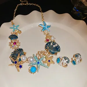 Starfish and shell necklace earring set with blue gemstones and pearls in gold finish