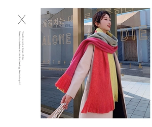 Close-up of soft thick knit scarf with colorful patchwork and tassel design on model