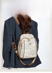 Detail of vintage wave pattern backpack with brown straps and gold zippers on model
