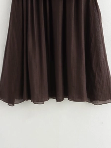 Detailed macro view of dark brown pleated fabric with semi-transparent texture and drapes