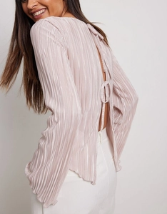Detail of pink pleated blouse featuring an open back with delicate lace-up tie design