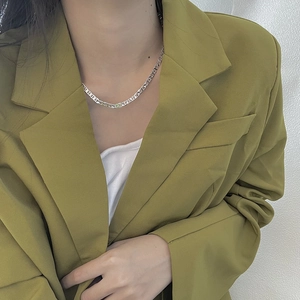 Close-up of S925 sterling silver pig nose chain necklace on a model with green blazer
