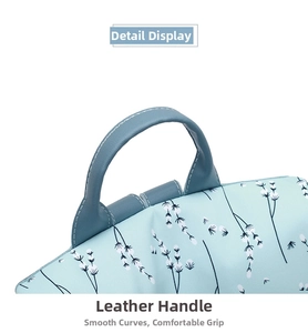 Détail de la poignée en cuir et du motif floral sur le sac à dos bleu clair