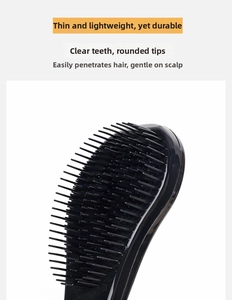 Close-up of black massage hairbrush with ergonomic handle and round tipped bristles