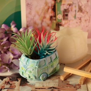 Detail van een retro bus siliconen mal en afgewerkte blauwgroene succulenten bloempot