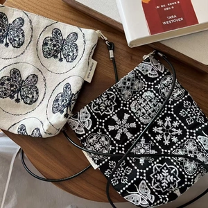 Gros plan sur la broderie raffinée de papillons et fleurs sur sacs en toile rétro