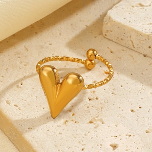 Gold heart open ring with textured hammered band on elegant beige stone backdrop