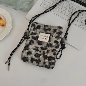 Gros plan sur le sac à bandoulière en peluche à motif léopard gris et noir sur un bureau