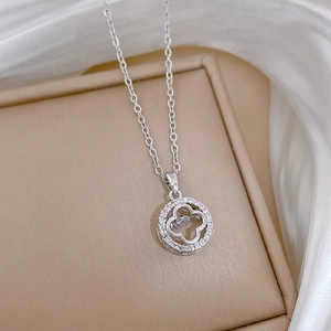 Macro shot of silver four-leaf clover pendant with sparkling zircons on jewelry box