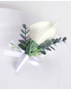 Detail of white calla lily boutonniere with eucalyptus leaves and a white ribbon bow