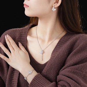 Close-up of elegant silver butterfly jewelry set with zircon stones on a female model
