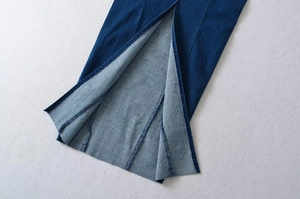 Detaillierte Nahaufnahme des Schlitzsaums und der Nähte an einem dunkelblauen Jeanskleid