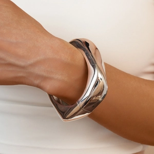 Primo piano di un bracciale a fascia irregolare in argento con finitura a specchio lucida