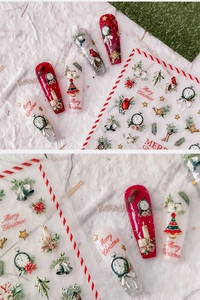 Macro detail of Christmas nail stickers with festive trees, bells, and holiday patterns