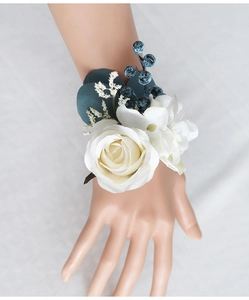 Close-up of elegant cream white and navy blue silk rose wrist corsage for bridesmaids