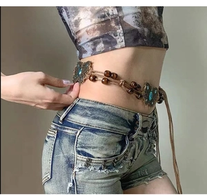 Detail of bohemian waist chain with metal butterflies and blue stone on woven cord