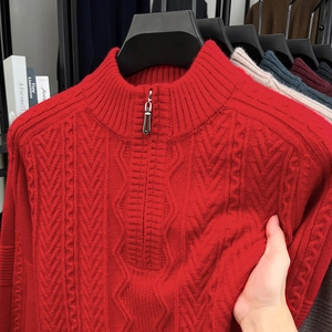 Close-up of red cable knit sweater fabric showing elasticity and zipper detail