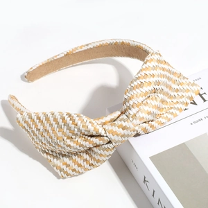 Detailed macro view showing beige and white woven straw texture and bow on the headband
