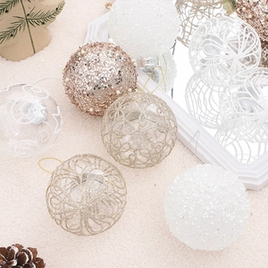 Set of 8cm painted Christmas balls in white and gold displayed on a festive background