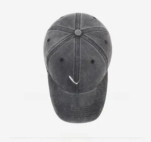 Top-down view of a dark grey washed denim baseball cap with a white heart embroidery
