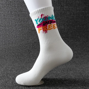 White sports socks with colorful YOUNG AND FREE graffiti print on textured background