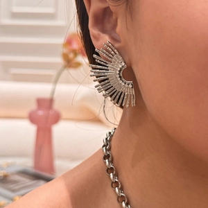 Detail view of silver fan-shaped sunburst earrings with zircon inlays on model
