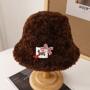 Détail d'un chapeau cloche en laine d'agneau marron avec écusson chiot mignon et nœud