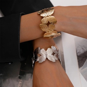 Detailed close-up of butterfly open cuffs featuring brushed metallic textures in gold and silver