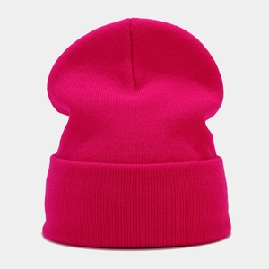 Detail of rose red cuffed knit beanie showing soft textured fabric for autumn and winter