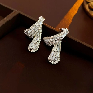 Gros plan de boucles d'oreilles en argent avec oxydes de zirconium baguette et rond