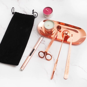 Rose gold stainless steel candle care set with trimmer and snuffer on marble background