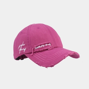 Close-up of distressed baseball cap with frayed edges and simple things embroidery