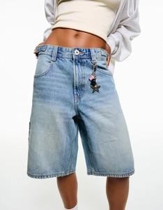 Detailstruktur der hellblauen High-Waist-Denim-Shorts mit Metallring-Accessoire