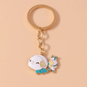 Close-up of white enamel koi fish keychain with gold hardware on soft background