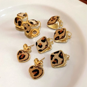 Dettaglio di orecchini placcati oro 18K quadrati e a cuore con stampa leopardata su vassoio