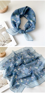 Detail showing blue floral cotton linen scarf with daisy print and soft texture