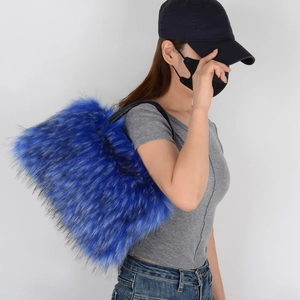 Close-up of fluffy blue faux fur tote bag showing texture and black shoulder strap detail