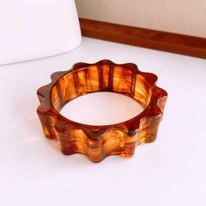 Vue détaillée du bracelet en acrylique écaillé avec bords ondulés et texture marbre