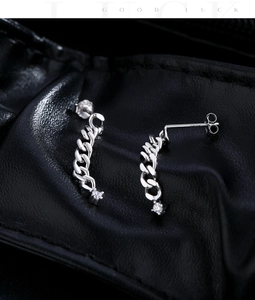 Nahaufnahme von S925 Silber-Kettenohrringen mit Glitzersteinen auf schwarzem Leder