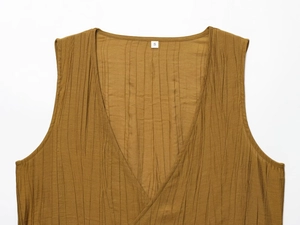 Detailed close-up of brown crinkle fabric texture on sleeveless top with size S label