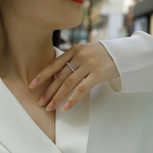 Close-up of elegant 925 sterling silver moissanite band ring worn on female finger