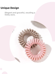 Detailed shot of pink and taupe spiral telephone wire hair ties with elastic resin texture