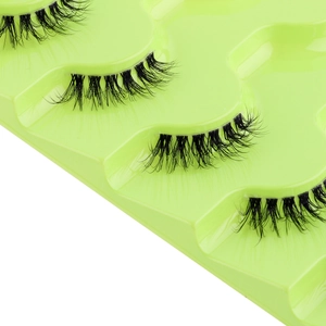 Detail of half false eyelashes on a green tray showing natural lash extension effect