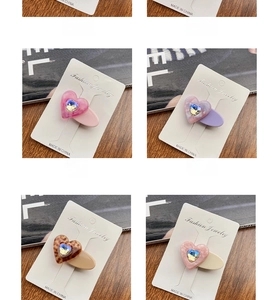 Detailed close-up of colorful heart-shaped rhinestone hair clips on cardboard
