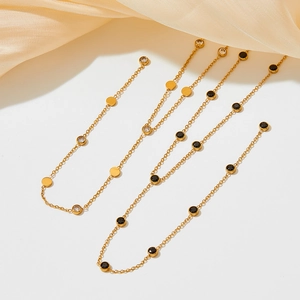 Elegant gold Y-shaped tassel necklace with cubic zirconia pendants on silk background