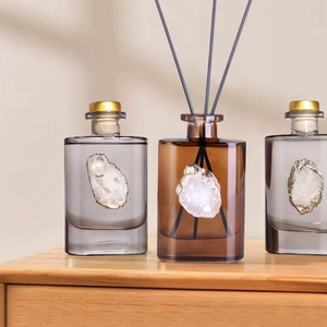 Agate stone reed diffuser set with amber and grey glass bottles on wooden base