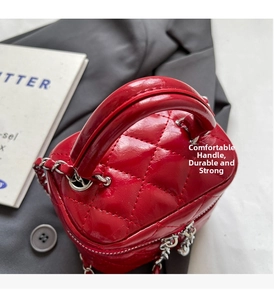 Close-up of red quilted leather mini box bag with sturdy handle and silver chain detail