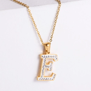 Detail of 18k gold plated letter E pendant necklace with sparkling inlaid crystals