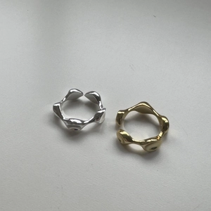 Close-up of minimalist irregular wavy rings in silver and gold molten metal finishes