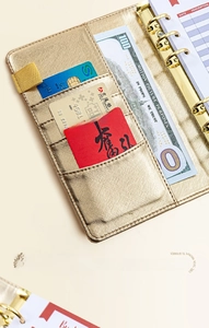 Detail view of champagne gold binder featuring card slots and budgeting inner pages